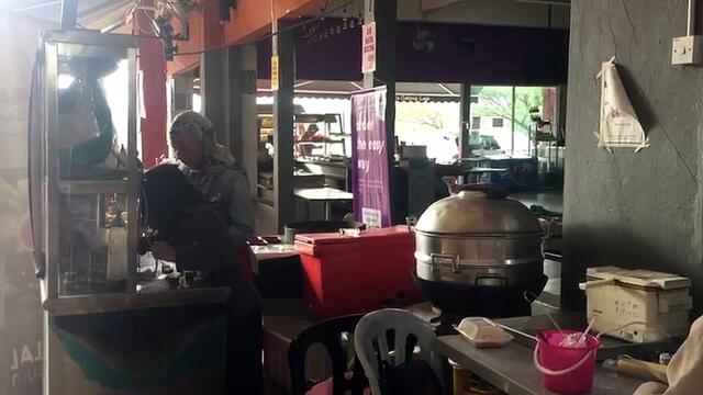 Alya takes an online class next to mother's stall