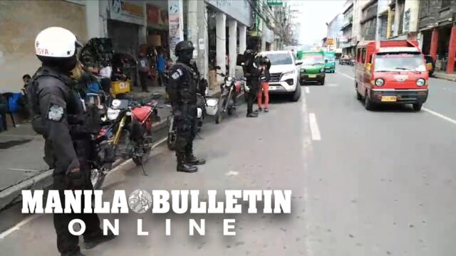 Members of the Davao City Police Office SWAT watch over the bustling commercial district area of the city