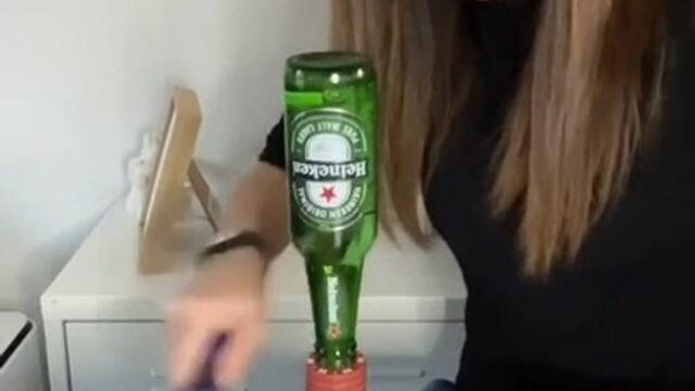 Woman Speedily Removes Casino Tokens From Under Inverted Beer Bottle