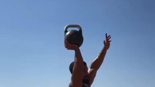 Fitness Professional Swings And Balances Heavy Kettlebell on His Hand