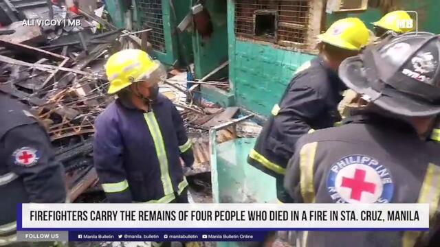 Firefighters carry the remains of four people who died in a fire in Sta. Cruz, Manila