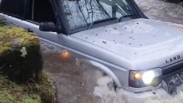 Tall Car Gets Stuck Under Bridge While Driving Through Stream of Water