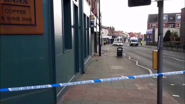 A Wigan road remains closed after a car hit a woman and two men outside a bar