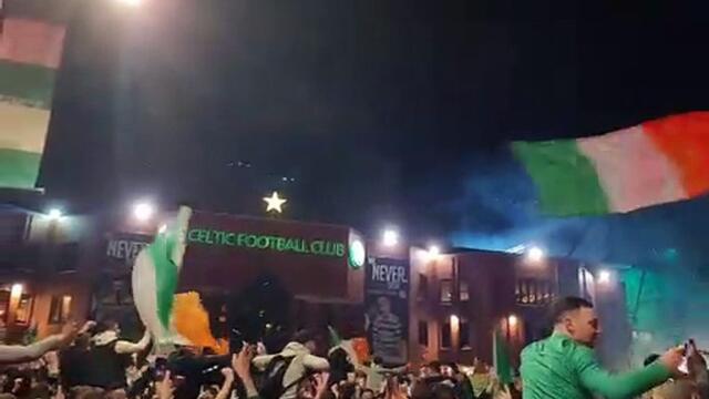 Celtic fans sing outside Celtic Park as they await the team