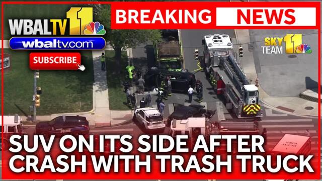SUV turns onto side in collision with trash truck
