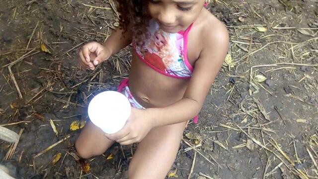 Menina 4 anos ordeando (tirando leite da vaca)