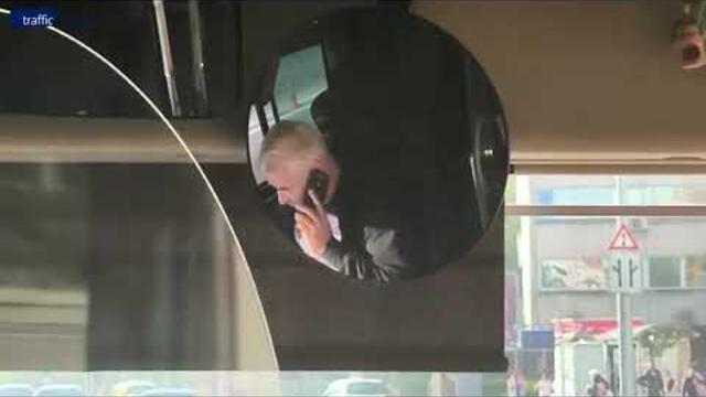 Шофьор на градския транспорт говори по телефона в движение