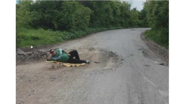 Мъж легна в огромна дупка на пътя в знак на протест